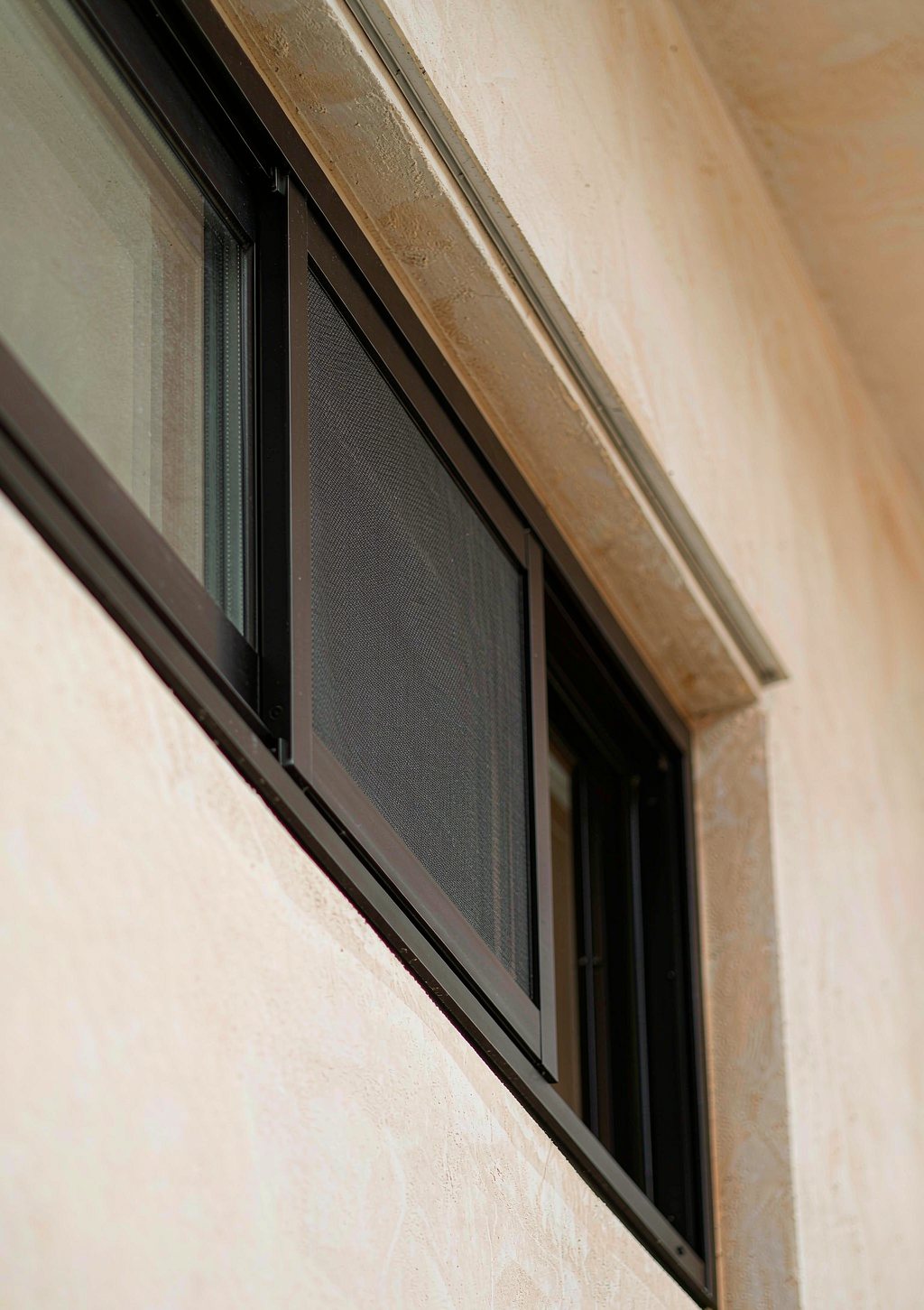 Slim matte black aluminum window frame with a flush integrated screen